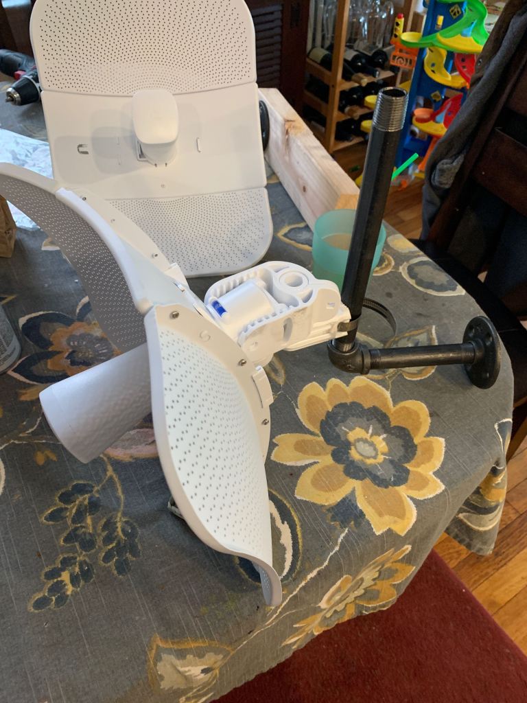 Two LiteBeam dishes with attached mounting kits, resting on a dining room table.